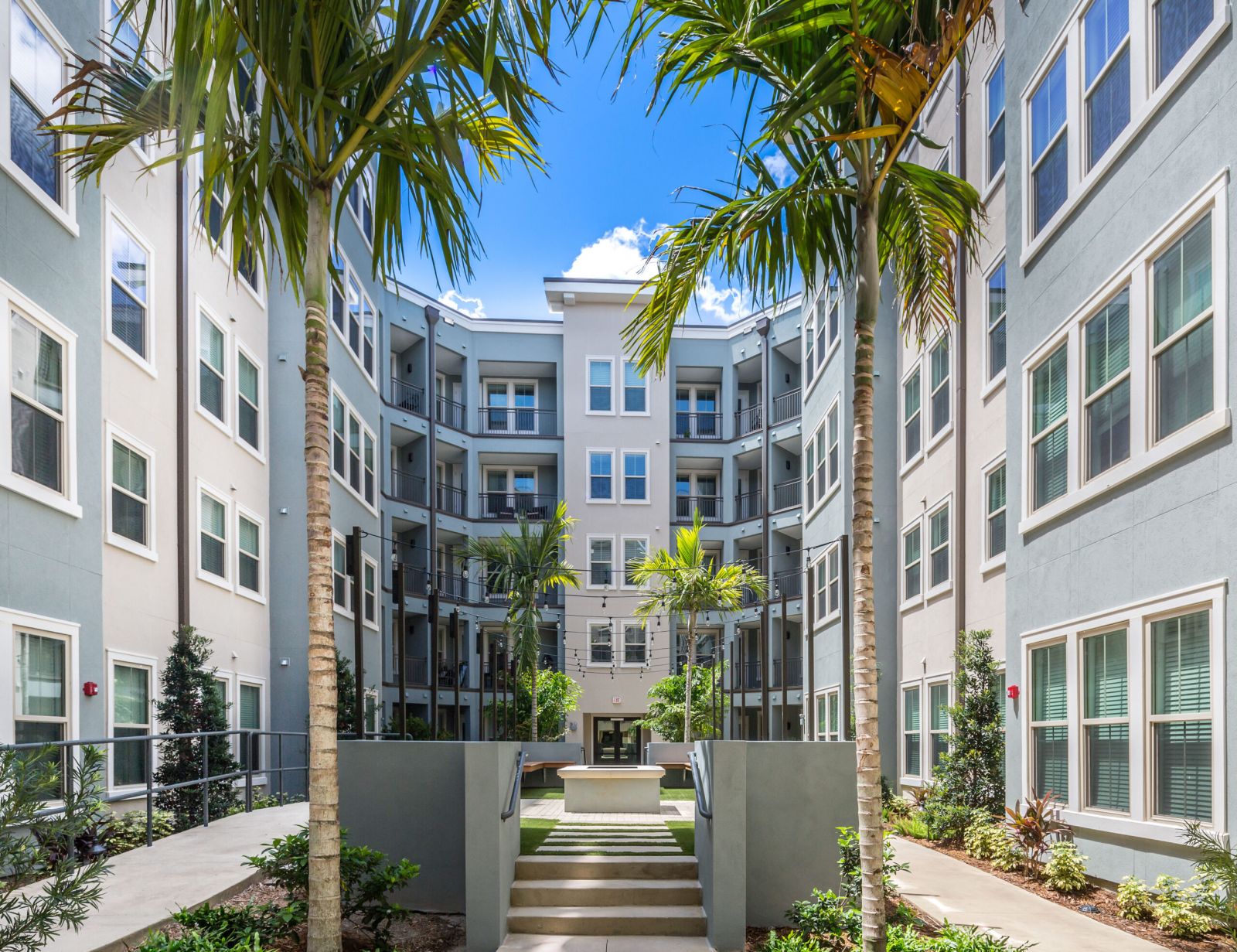 Northwood Ravin Property Management Portfolio, THE LUCENT AT SUNRISE in Kissimmee, FL, multi-family, multi-story apartments with balconies, green grass and palm trees