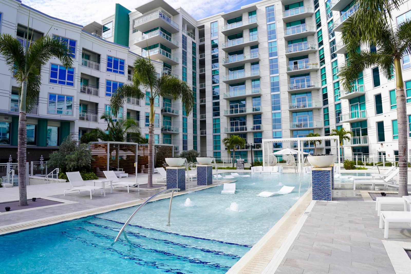 Northwood Ravin Property Management Portfolio, THE EMERSON AT ROCKY POINT in Tampa, FL, multi-family, multi-story apartments with mid-rise and high-rise buildings, large balconies, and large pool with palm trees