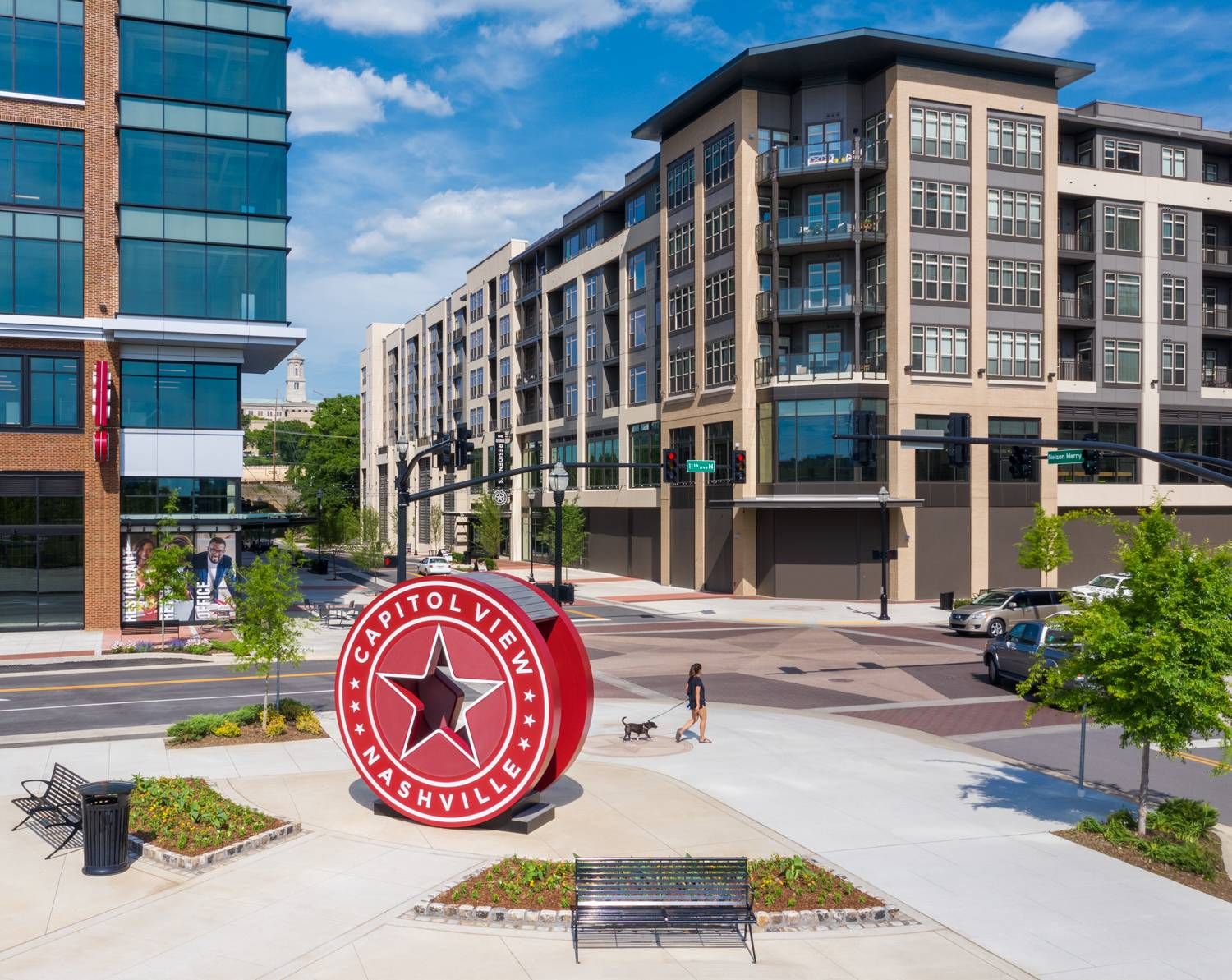 Northwood Ravin Property Management Portfolio, RESIDENCES AT CAPITOL VIEW in Nashville, TN, multi-family, multi-story apartments showing the building exterior with plentiful windows, green trees, and retail shops on the first floor