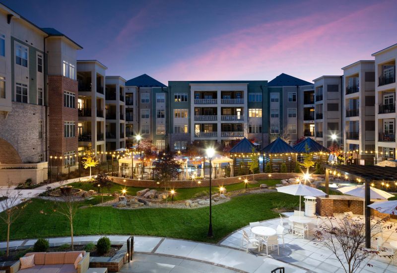 Northwood Ravin Property Management Portfolio, PROVIDENCE ROW in Charlotte, NC, a multi-family, multi-story apartment building exterior with large balconies overlooking a courtyard surrounded by green grass and a pool with cabanas